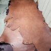 Leather hides stacked on a workshop table.