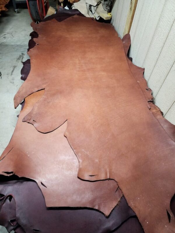 Leather hides stacked on a workshop table.