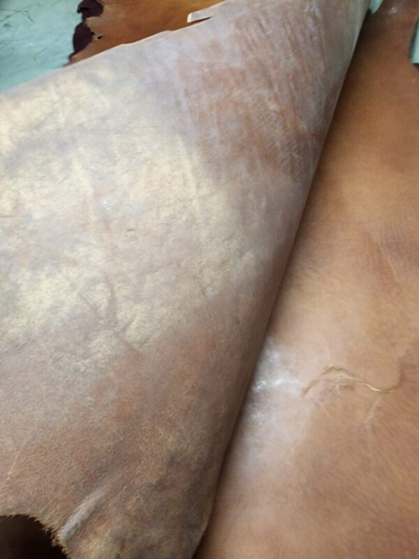 Brown leather hides stacked in layers.