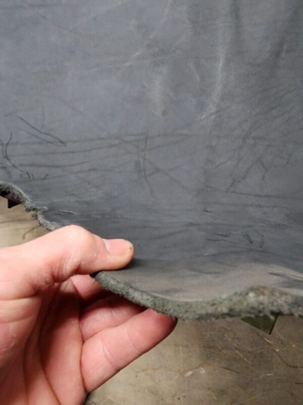 20240215_180939 Hand holding a flexible rubber sheet edge.