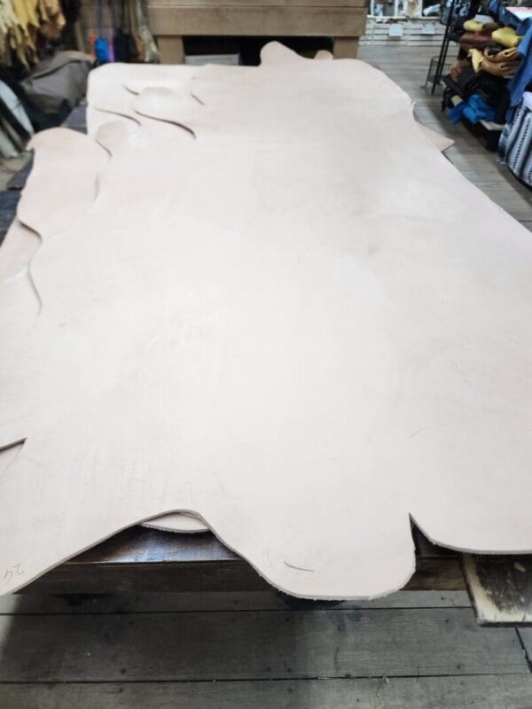 20240227_171515 Large sheets of light-colored leather on table.