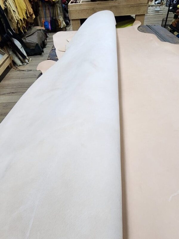 Large rolls of leather on wooden table.