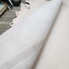 Rolled leather sheets on wooden table.