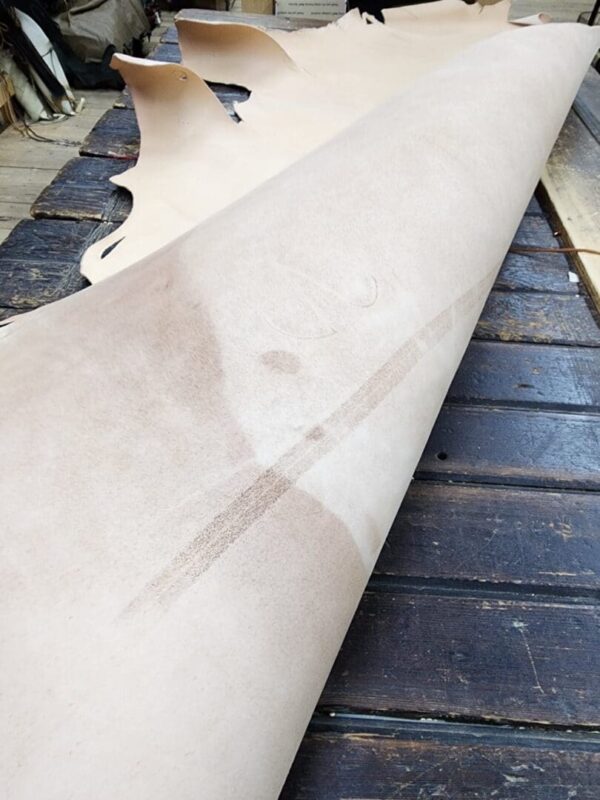 Rolled leather hide on wooden table.