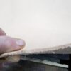 Person holding a piece of leather.