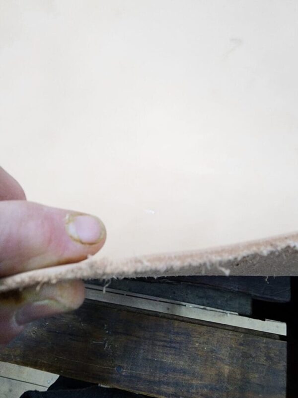 Person holding a piece of leather.