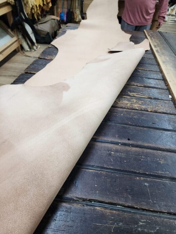 Leather roll on wooden table in workshop.
