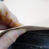 Hand holding a piece of leather.