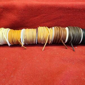 20240313_104322 Colorful leather laces on red background.