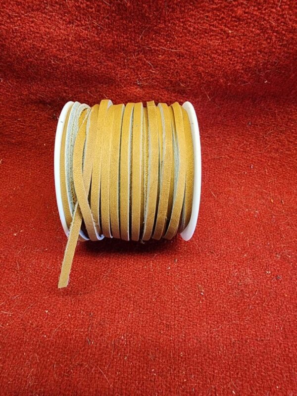 Spool of brown suede laces on red.