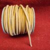 Yellow leather cord on red fabric background.
