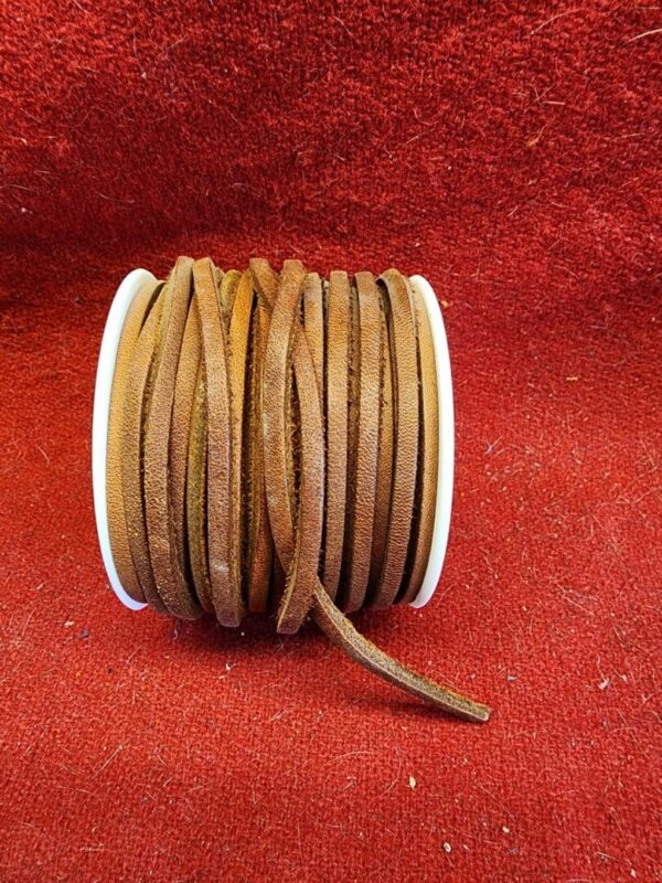 Brown leather cord on red fabric background.