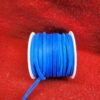 Blue ribbon spool on red fabric background.