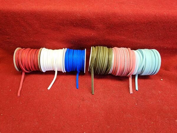 Colorful spools of thread on red fabric.