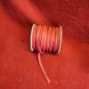 Red cord spool on matching red background.