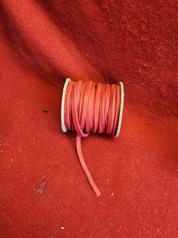 Red cord spool on matching red background.