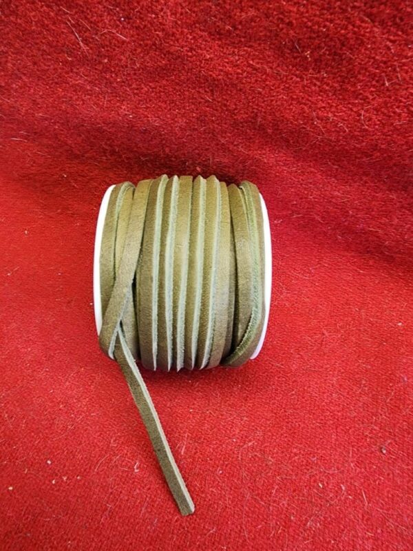 Brown suede cord roll on red fabric.