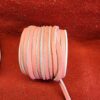 Roll of pink leather strips on fabric.