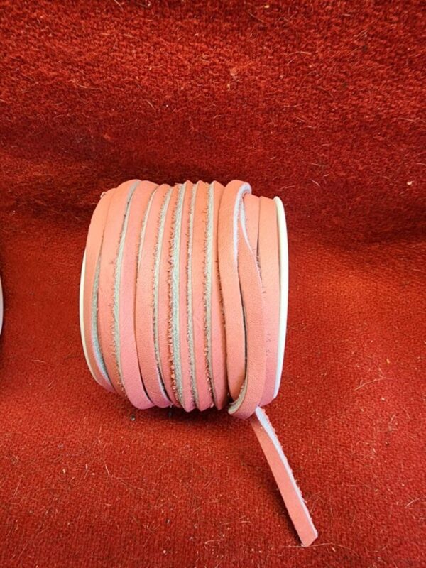 Roll of pink leather strips on fabric.