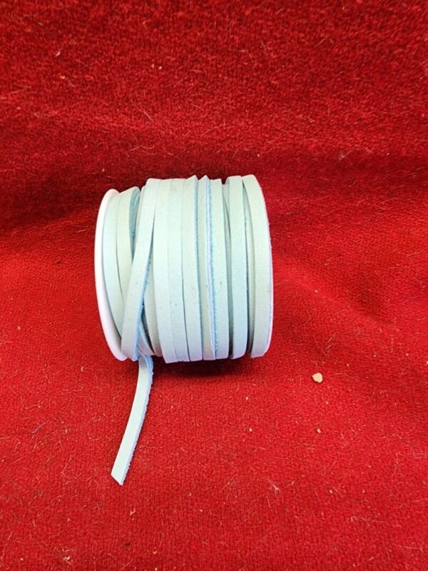 White shoelace roll on red fabric.