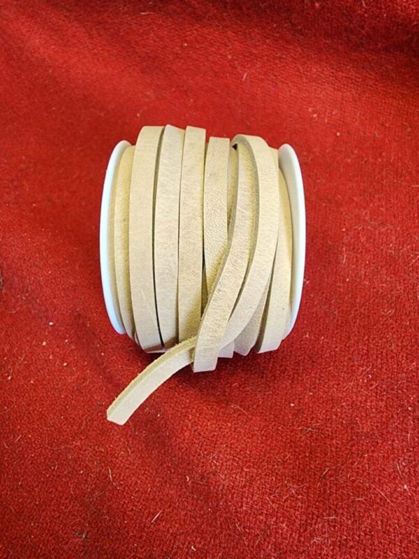 Beige leather strap roll on red fabric.