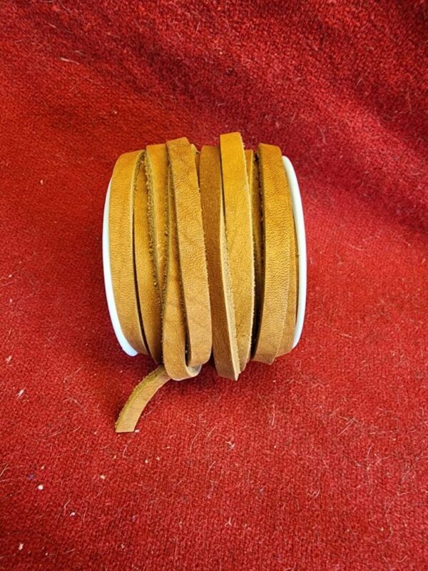 Brown leather strap on red fabric background.