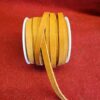 Spool of brown leather strips on fabric.
