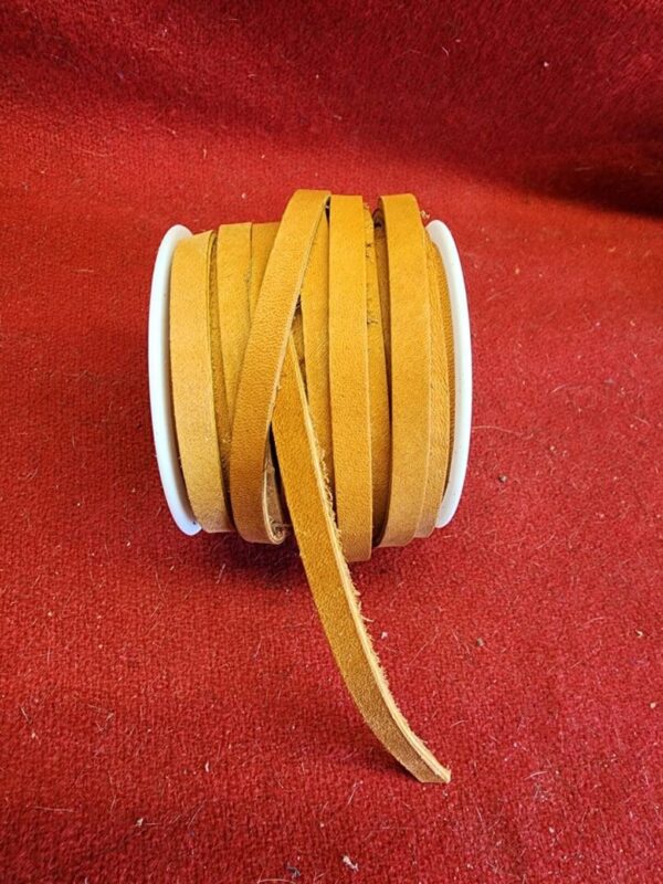 Spool of brown leather strips on fabric.