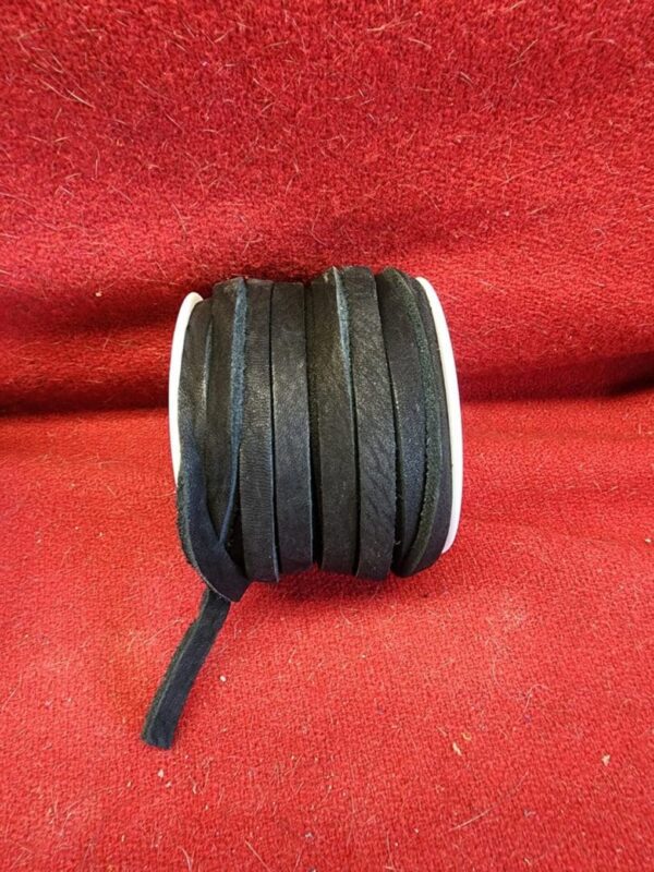 20240313_132719 Black ribbon spool on red background.