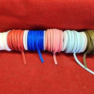 20240313_133616 Colorful shoelaces on red fabric background.