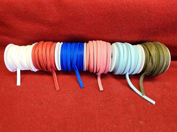 20240313_133616 Colorful shoelaces on red fabric background.