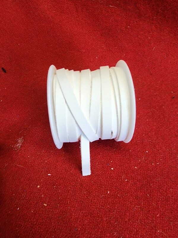 20240313_133619 White ribbon spool on red background.