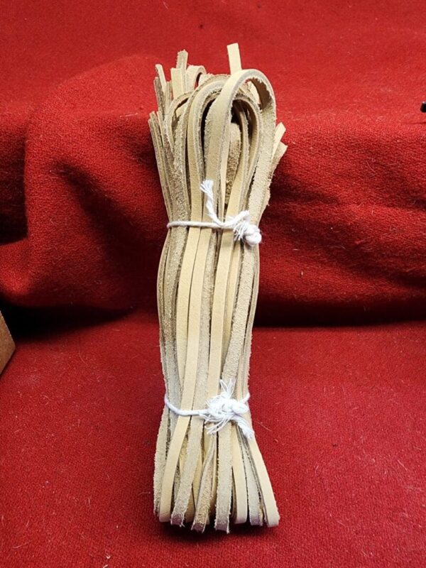 Bundle of tan leather strips on fabric.
