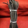 Bundle of black leather strips on red.