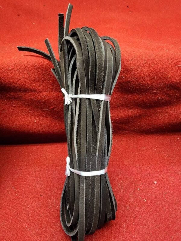 Bundle of black leather strips on red.