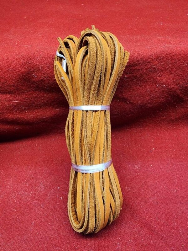 Bundle of brown leather laces on fabric.