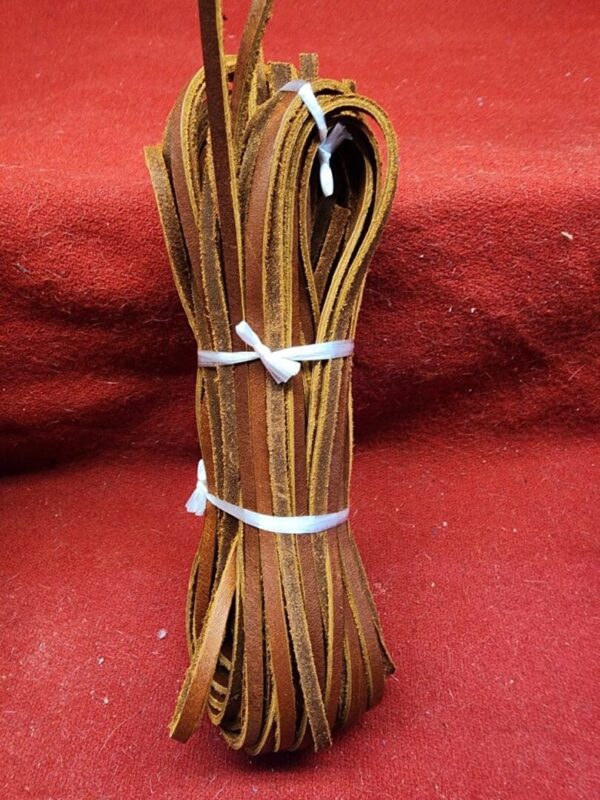 Bundle of brown leather strips on red.