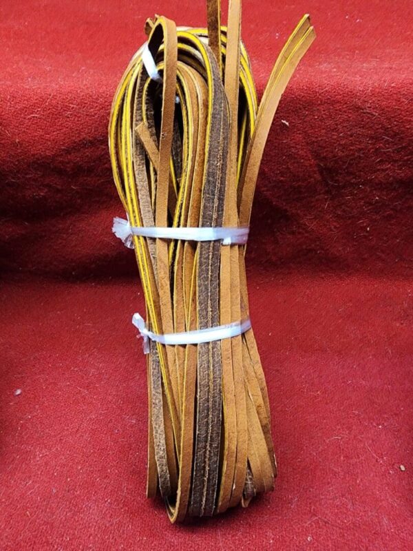 Bundle of leather strips on red background.