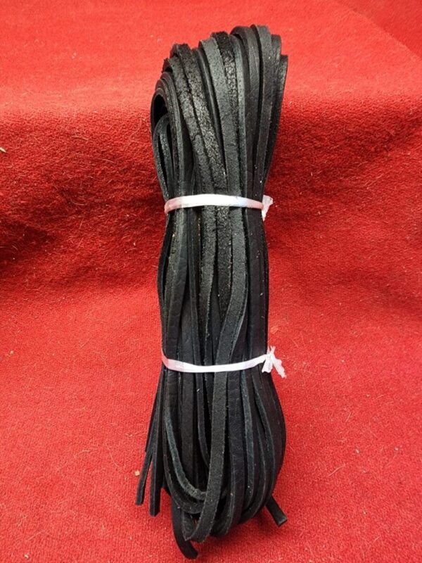 Black leather strips on red fabric background.