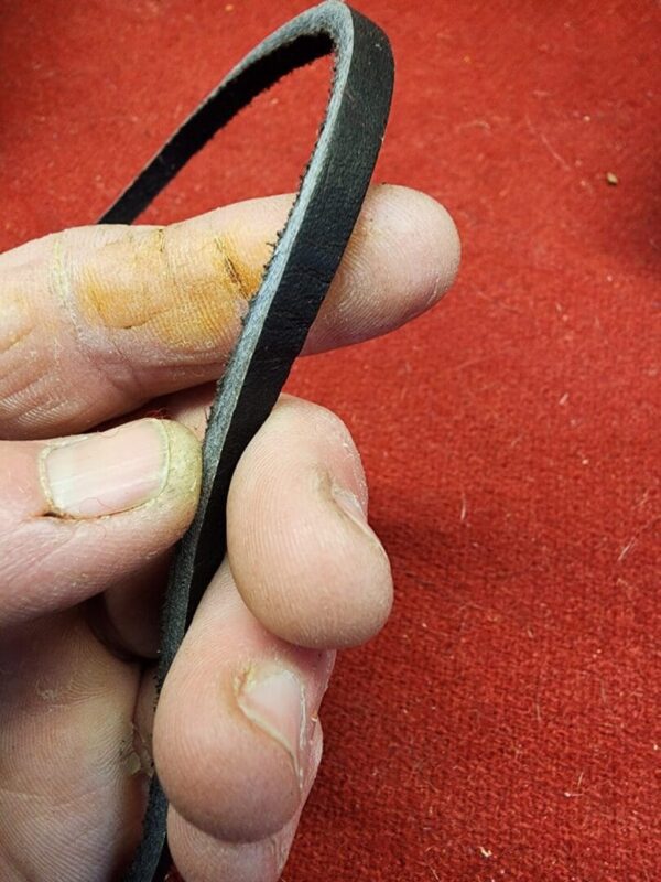 Hand holding a worn rubber belt.
