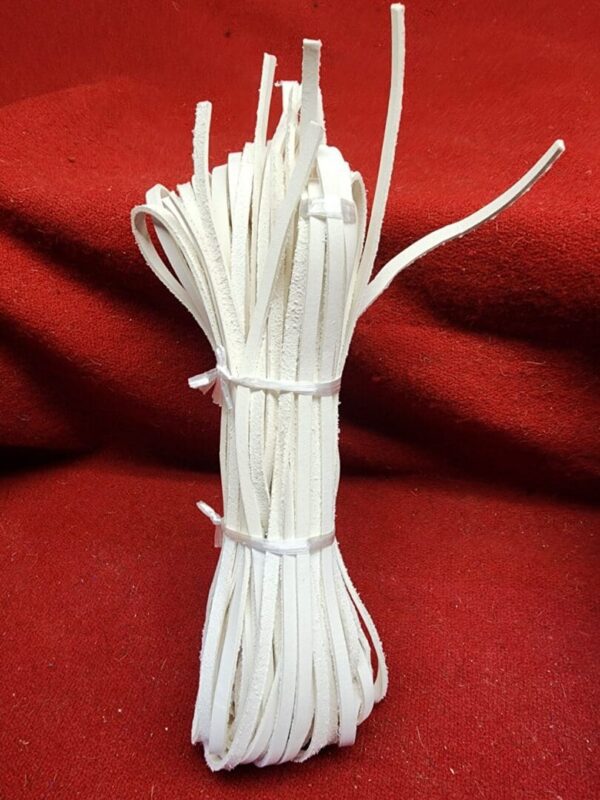 Bundle of white leather laces on fabric.