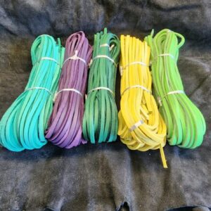 20240507_162709 Colorful bundles of laces on dark fabric.