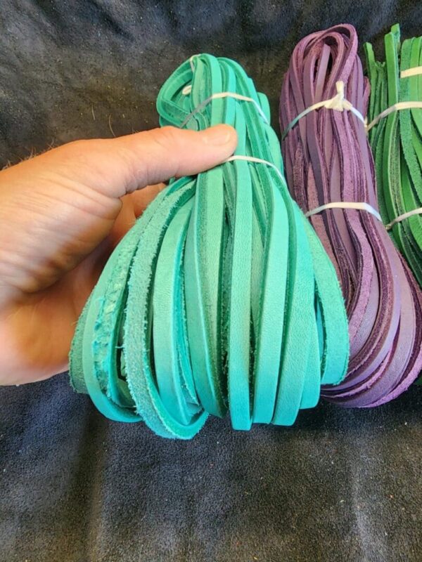 Hand holding bundle of colorful fabric strips.