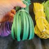 Hand holding colorful leather strips bundles.