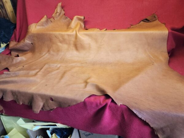 Brown leather hide on red fabric.