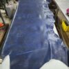 Blue leather hide on a workshop table.