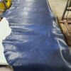 Blue leather hide on a workshop table.