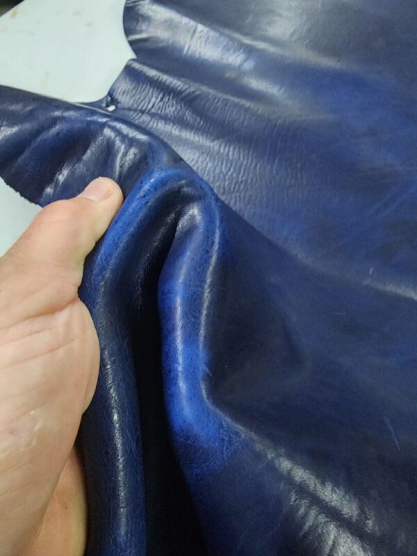 Hand holding a piece of blue leather.