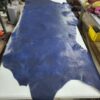 Large blue leather piece on a work table.