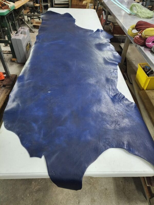 Large blue leather piece on a work table.
